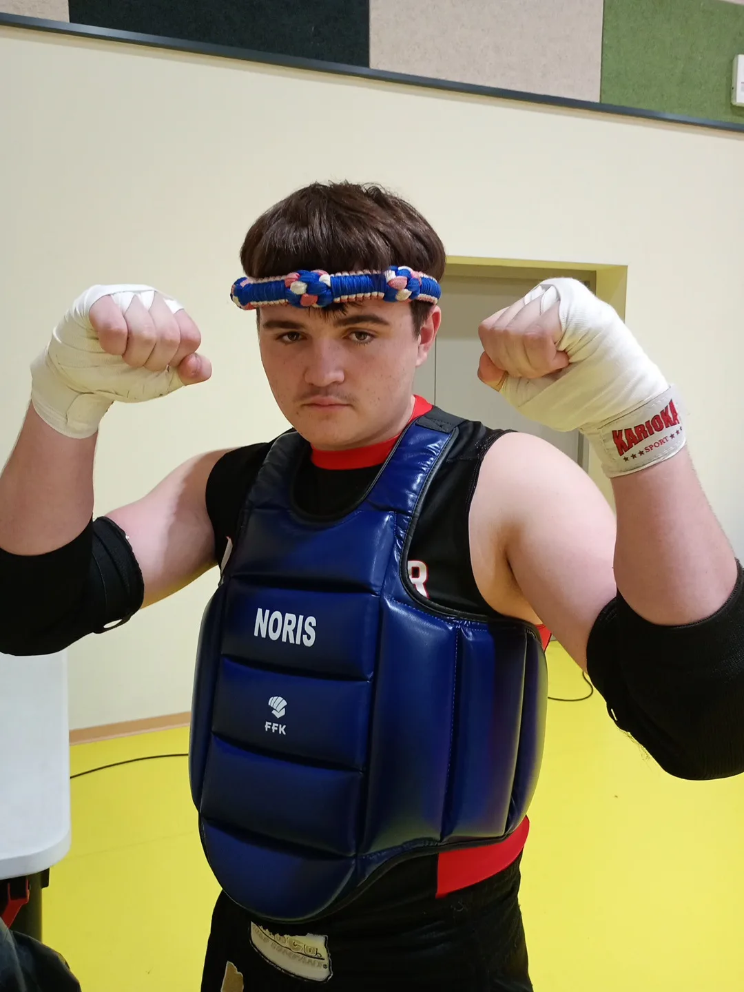 Jeune compétiteur en plastron bleu avant son combat